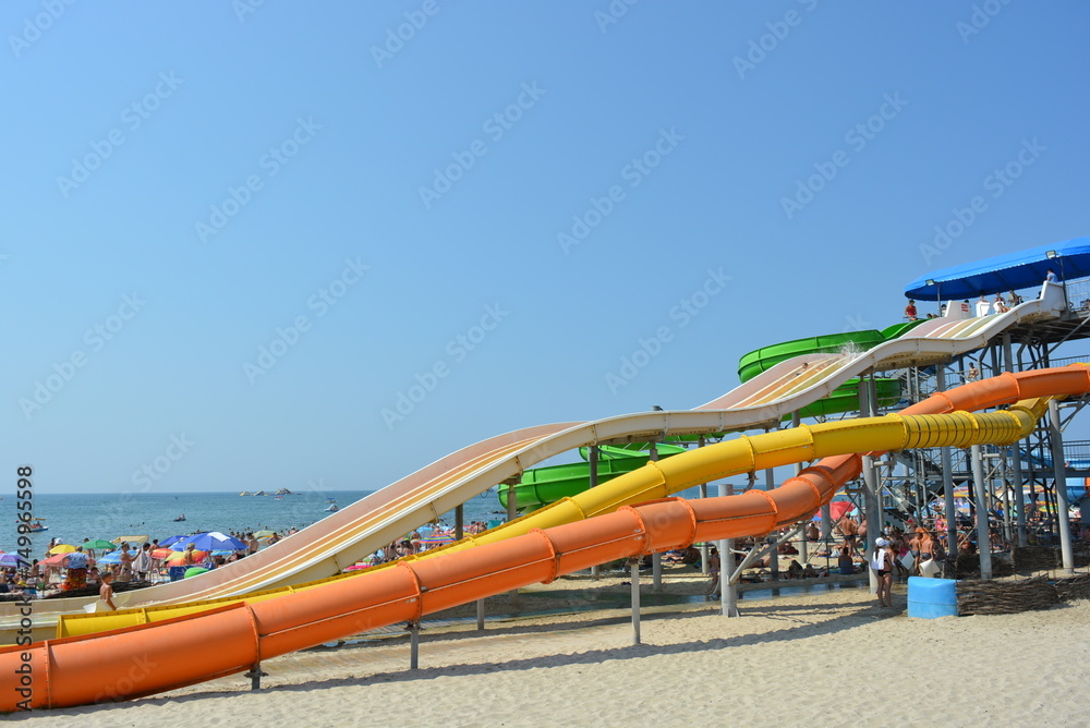 Water inflatable attraction of red, yellow and blue, a water furnace with a pool on the beach of the Black Sea