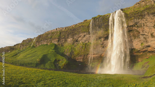 Obraz na płótnie The Seljalandsfoss waterfall on the south coast of Iceland bathed in the otherworldly light of the midnight sun. The waterfall drops 60 meters and is part of the Seljalands River. w salonie
