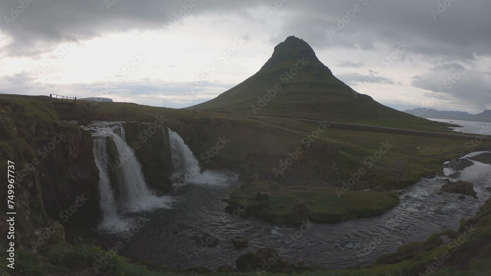 Waterfall Kirkjufellsfoss and Mount Kirkjufell. Kirkjufell is a picturesque mountain that rises above Grundarfjordur Town in the Snaefellsness Peninsula, Iceland.