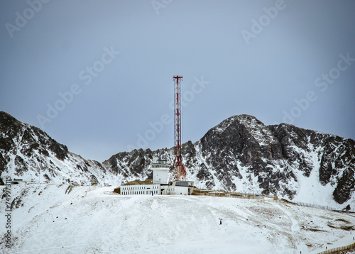 Scenic shot of Telecommunications antenna tower with background snow-covered mountains in Andorra