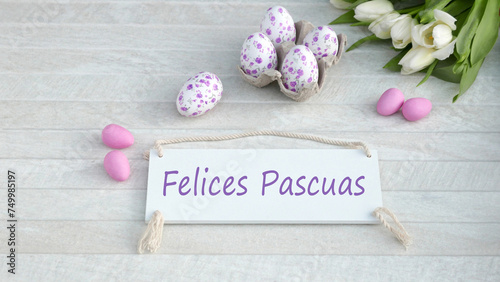 El texto Felices Pascuas escrito en un cartel con decoraciones de Pascua.