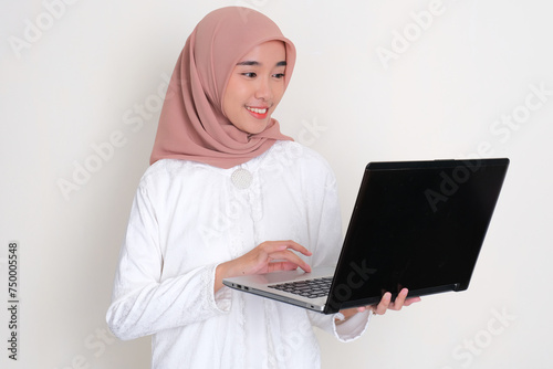Moslem Asian woman working using a laptop