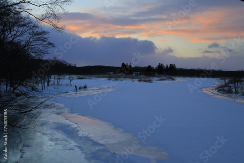 北海道野付湾に流れる春別川ゆっくり 流れ冬場凍り付きます。 氷面に映り込みが美しく夕陽が沈んでゆきます。  © 汐理 宮本