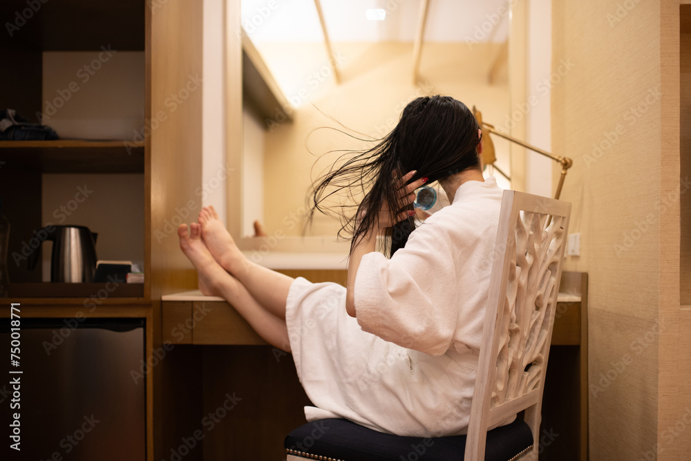 髪を乾かすバスローブを着た女性 髪を乾かすバスローブを着た女性