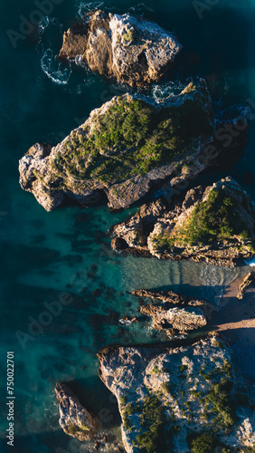 Top aerial view from flying drone of beautiful ocean sea coast landscape with turquoise water and mountains covered with green grass. Copy space for advertising message  promotional content. Vertical