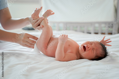 newborn male Is a person of Asian descent Lying in the bedroom on a white bed I'm crying.