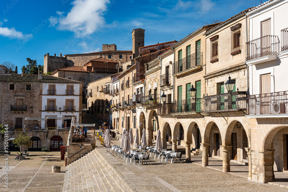 Noble houses with stone arches and balconies next to the main square of Trujillo, Spain.
