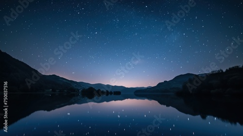 Starry night over tranquil lake surrounded by majestic mountains