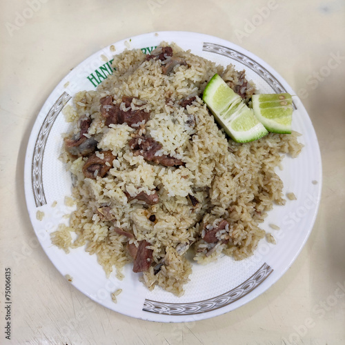 Old Dhaka famous Hanif Biriyani tehari a traditional  rice item of Bangladesh cooked with mutton, beef served in white bowl wooden background.  photo