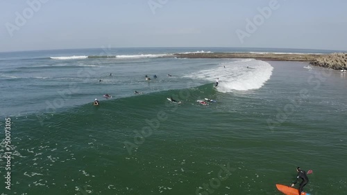 Aerial view of longboard surfers waiting at line up to surf at Atlantic Ocean, Imsouane, Morocco. photo