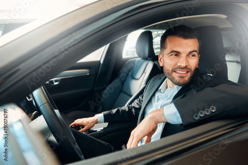 Businessman in a black suit in a car.