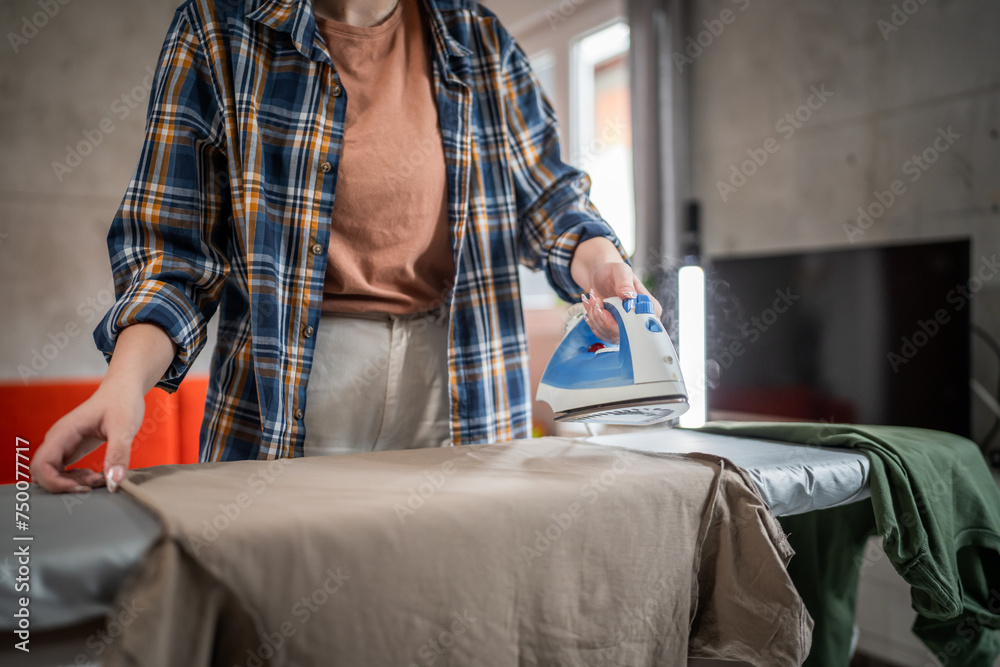 one woman ironing clothes at home hold iron household chores concept