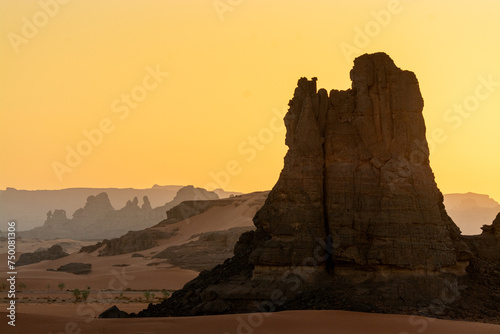 Landscape of the Red Tadrart in the Sahara Desert, Algeria. Sunset behind wind-sculpted sandstone rock formations