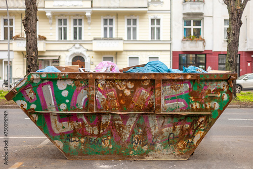Rostiger Container mit Müllsäcken auf der Straße