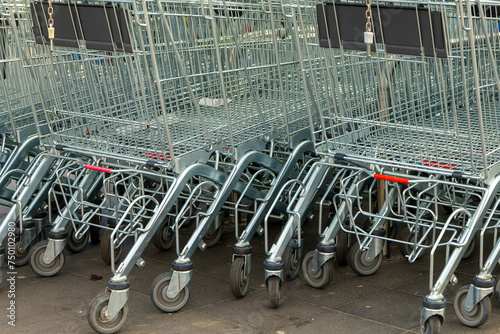 row of shopping carts are lined up on the ground