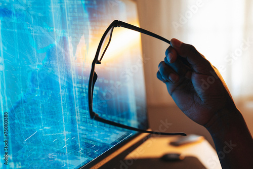 Canvas Print Man's hand holding glasses. background with blue computer screen