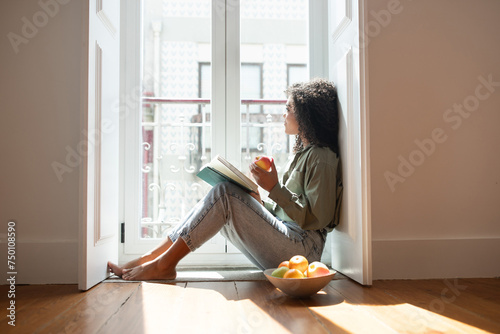 Brazilian lady engrossed in a book reading in apartment indoor