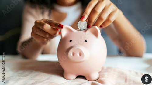 woman's hands with pink polished nails depositing a silver coin into a pink piggy bank, representing savings and financial planning.