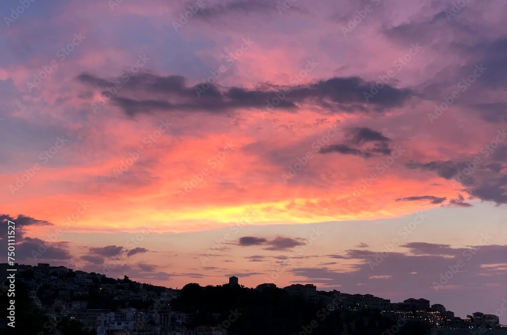 Dramatic sky sunset clouds above old town at evening.