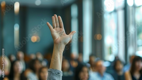 A group of diverse individuals sitting in a room with their hands up, engaging in a discussion or activity