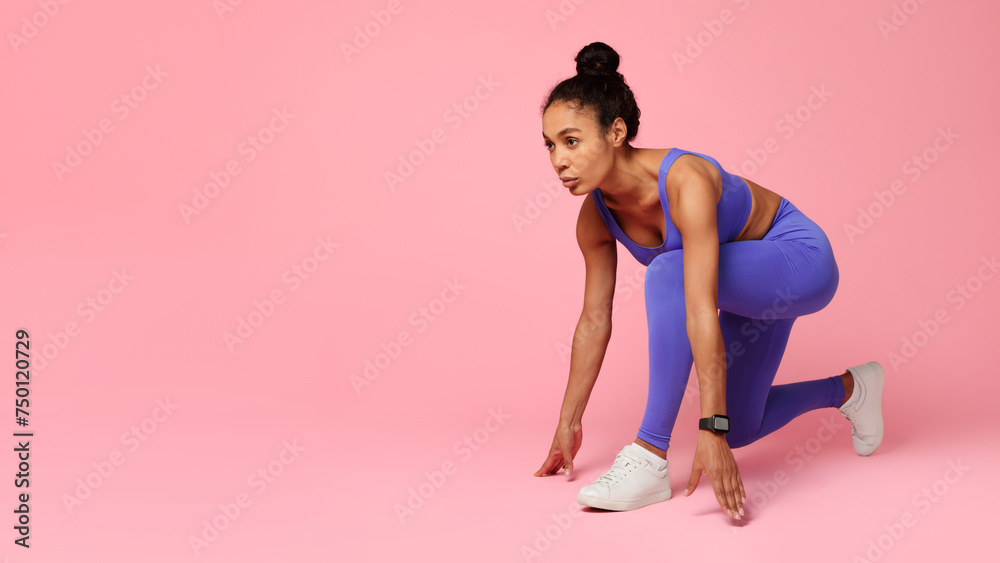 black woman in sporty attire crouches ready for running, studio black woman in sporty attire crouches ready for running, studio