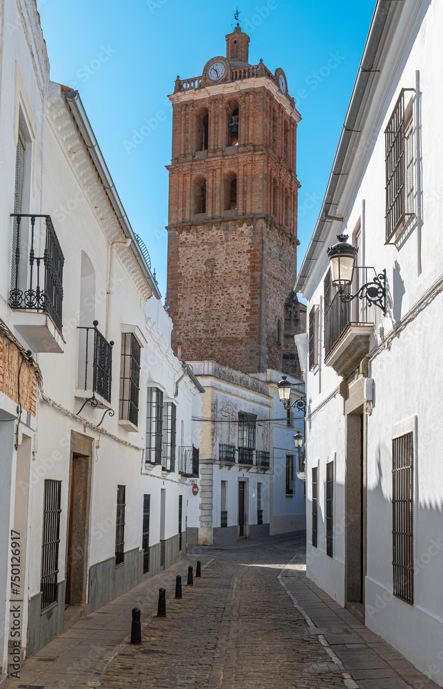 Una calle peatonal de casas blancas en la villa española de Zafra con el campanario de la parroquia de la Candelaria, España