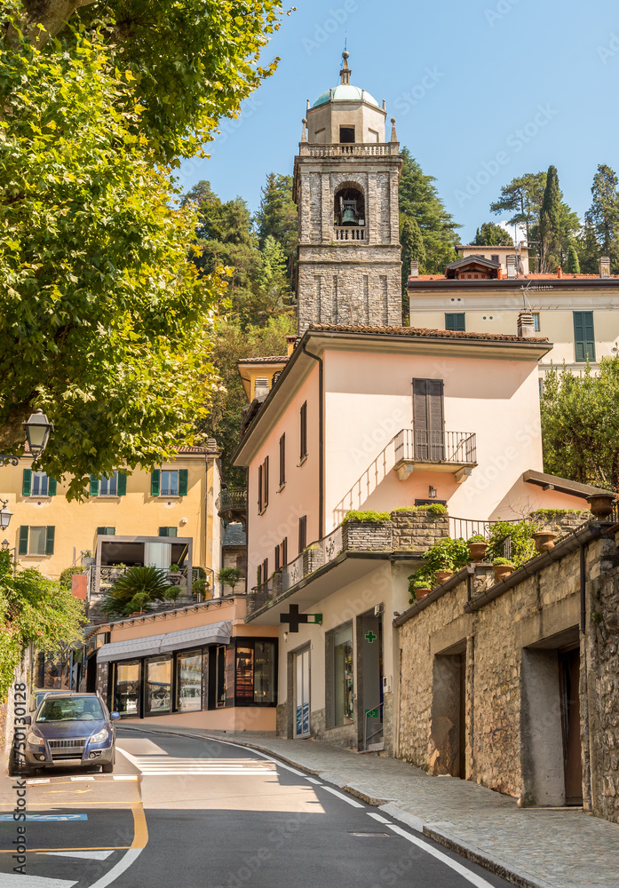Street with view of the bell tower of the San Giacomo church in the picturesque village Bellagio on Lake Como, Lombardy, Italy