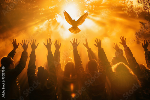 Crowd of people raising hands worshiping the Holy Spirit flying over the crowd of believers photo