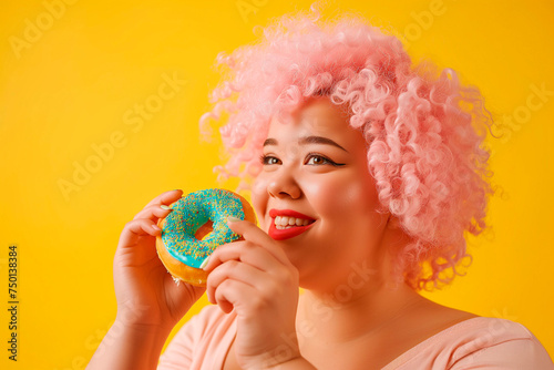 Cheerful curvy woman holding donuts. Plus size young woman ready to eat donut with frosting.
