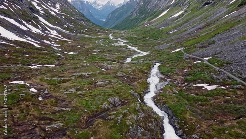 mountain road through a valley with rivers and waterfalls