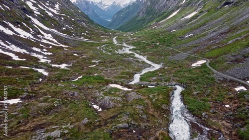 mountain road through a valley with rivers and waterfalls