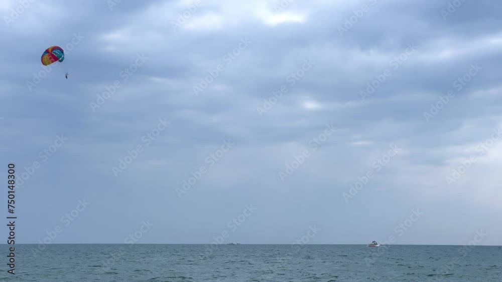 Parasailing: a boat with a marine parachute on the waves. The concept of a cloudy landscape, freedom and summer. Parachutists over the surface of the Black Sea against the sky on a summer day. 4K Parasailing: a boat with a marine parachute on the waves. The concept of a cloudy landscape, freedom and summer. Parachutists over the surface of the Black Sea against the sky on a summer day. 4K