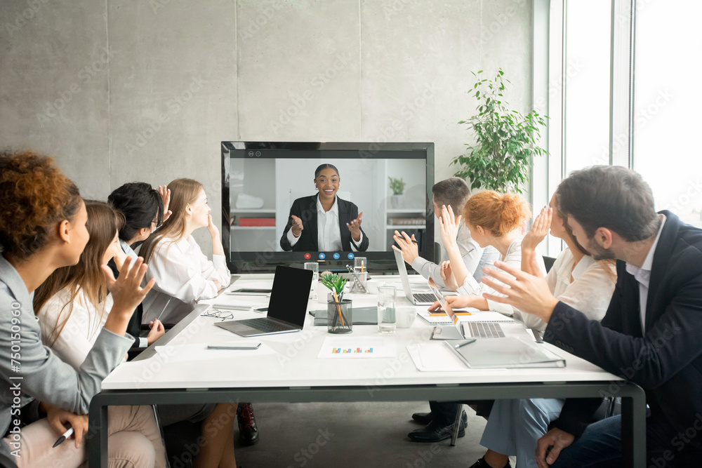 Videoconference. Businesspeople greeting boss, waving hands to screen Videoconference. Businesspeople greeting boss, waving hands to screen