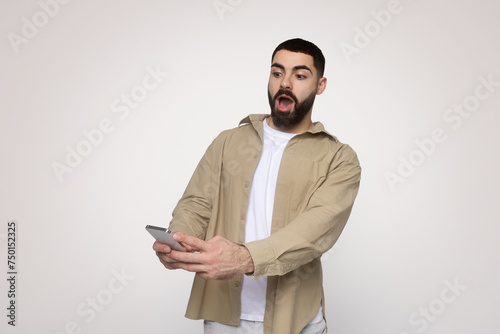 Shocked bearded man with wide-open mouth, wearing a beige shirt