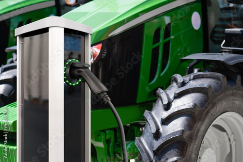Electric vehicles charging station on a background of agricultural tractors. Concept..