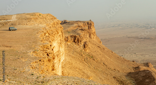 Car on the edge of the Jabal Tuwaiq Mountains, with desert landscape, Riyadh, Saudi Arabia