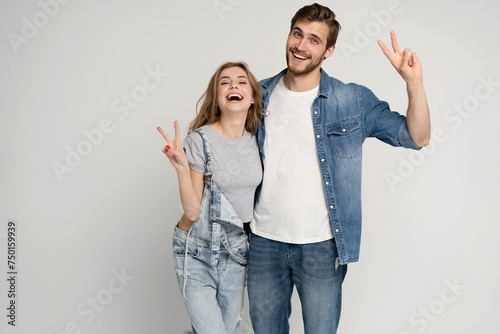 two amazing beautiful people lady handsome guy stand side by side showing v-sign symbols hands hugging wear casual denim shirts outfit clothes isolated on white background photo