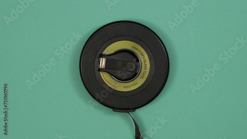 Vintage rounded tape measure. Tools in action on color background. Loopable stop motion animation. 4K top view. DIY video concept. photo