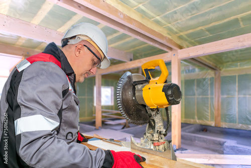 Builder saws boards. Man bu...