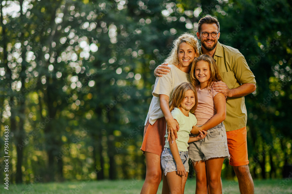 Portrait of a cheerful family standing together in nature and smiling. Portrait of a cheerful family standing together in nature and smiling.