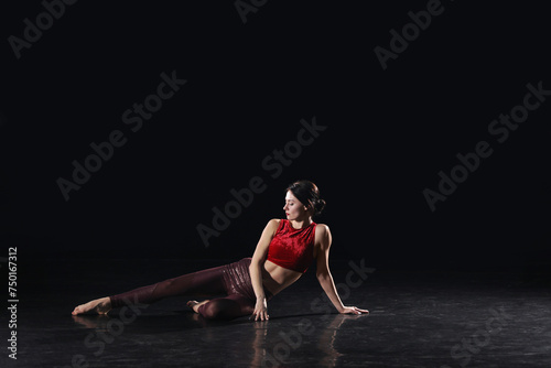 Young woman performing acrobatic element on stage indoors © New Africa