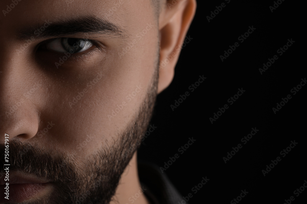 Obraz premium Evil eye. Man with scary eyes on black background, space for text