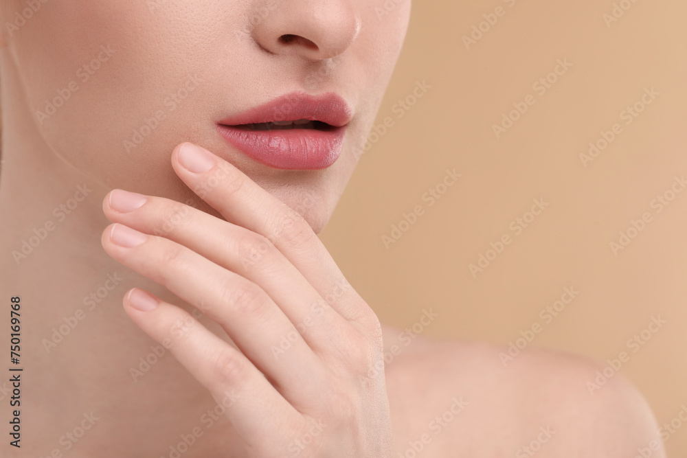 Obraz premium Young woman with beautiful full lips on beige background, closeup