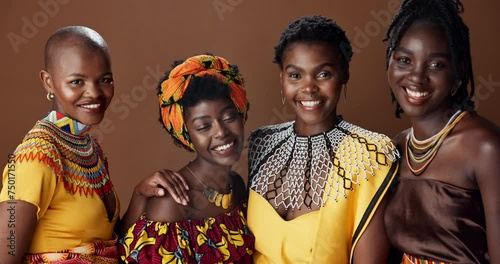 Traditional African women, friends and studio for face, jewelry or beads necklace in clothes by brown background. Black people, model and indigenous fashion for color, culture or portrait for kwanzaa photo