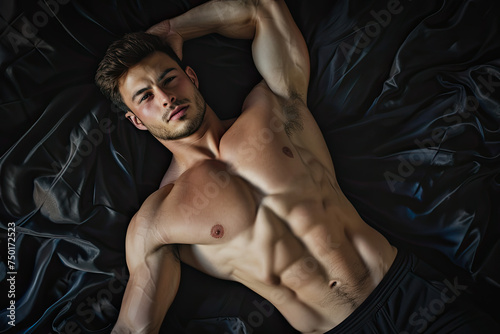 topview of shirtless muscular young man in bed