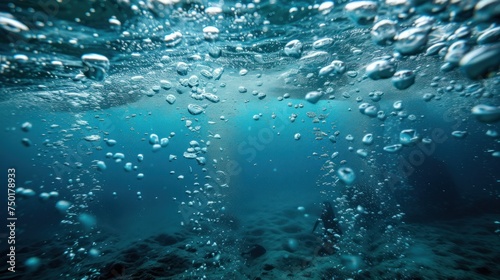  a group of bubbles floating on top of a blue ocean next to a body of water with a person standing in the middle of the water in the middle of the water.