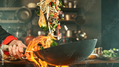Freeze Motion of Wok Pan with Flying Asian Meal in the Air.