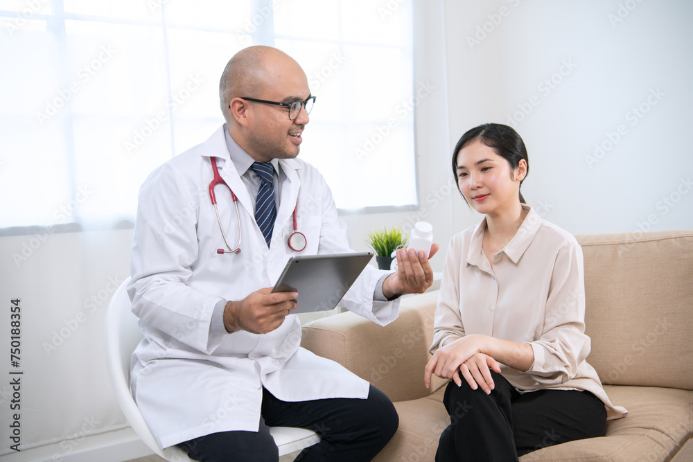 Foreign tanned male doctor in white medical clothes discussing woman's illness male doctor opens an iPad, shows treatment and medication information, and provides information of each drug. Foreign tanned male doctor in white medical clothes discussing woman's illness male doctor opens an iPad, shows treatment and medication information, and provides information of each drug.