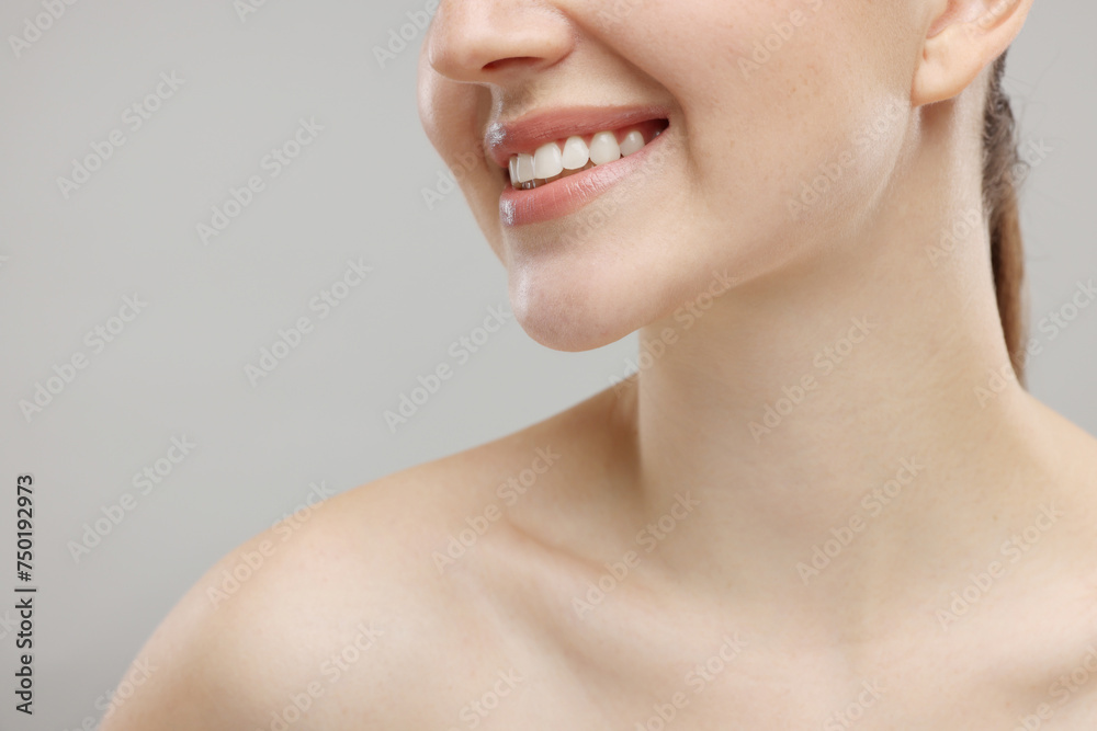 Beauty concept. Smiling woman on grey background, closeup Beauty concept. Smiling woman on grey background, closeup