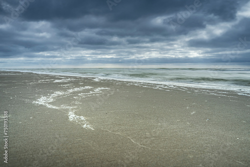 Dark clouds over sandy beach on the North Sea coast of the Netherlands